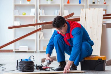 Genç marangoz ahşap kalaslarla çalışıyor.