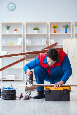 Genç marangoz ahşap kalaslarla çalışıyor.