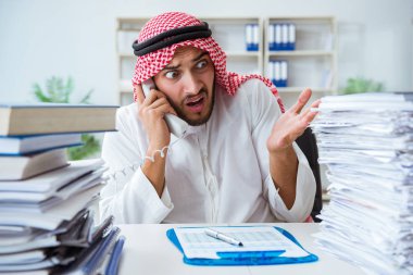 Ofiste çalışan Arap işadamı bir Pi ile evrak işi yapıyor.