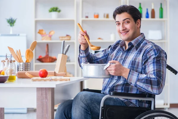 Engelli adam mutfakta çorba hazırlıyor.