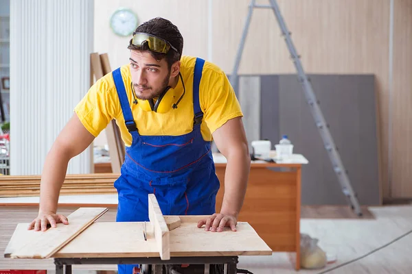 Genç bir marangoz dairesel testere ile çalışıyor.