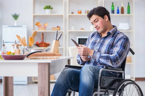 Engelli genç koca mutfakta çalışıyor.