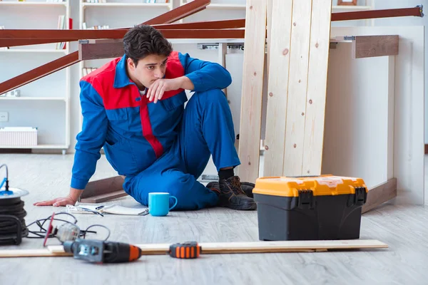 İnşaatta defter planlama yapan genç bir marangoz.