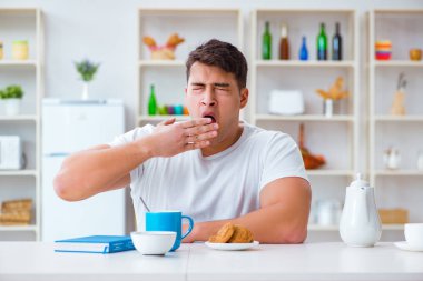 Fazla mesai sonrası kahvaltıda uyuyan bir adam.