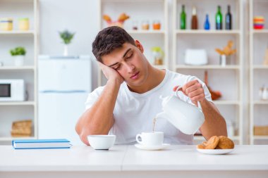 Fazla mesai sonrası kahvaltıda uyuyan bir adam.