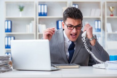 İşadamı ofisinde sigara içiyor.