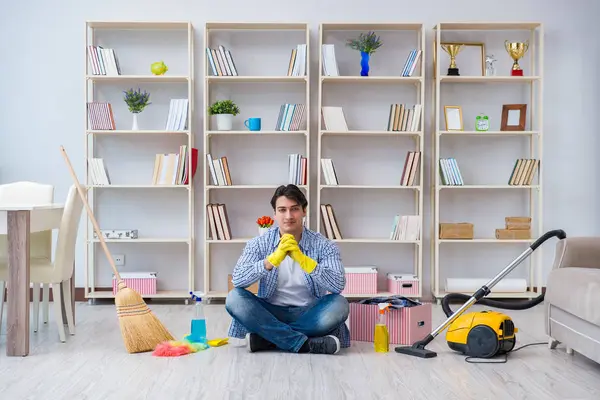 Adam evi temizliyor.