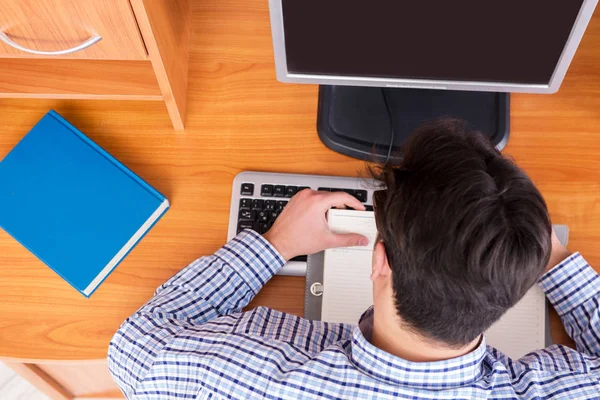 Joven estudiante en la mesa de computadoras —  Fotos de Stock