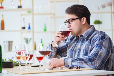 Profesyonel şarap garsonu kırmızı şarap tadıyor.