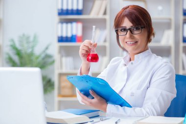 Bir laboratuarda deney yapan kadın bir bilim adamı.