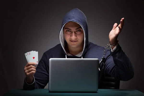 Junger Mann in Handschellen und Kapuzenpulli sitzt vor a la — Stockfoto