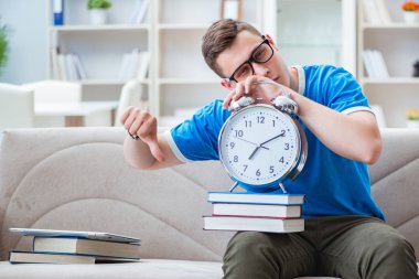 Sınavlara hazırlanan genç öğrenci kanepede ders çalışıyor.