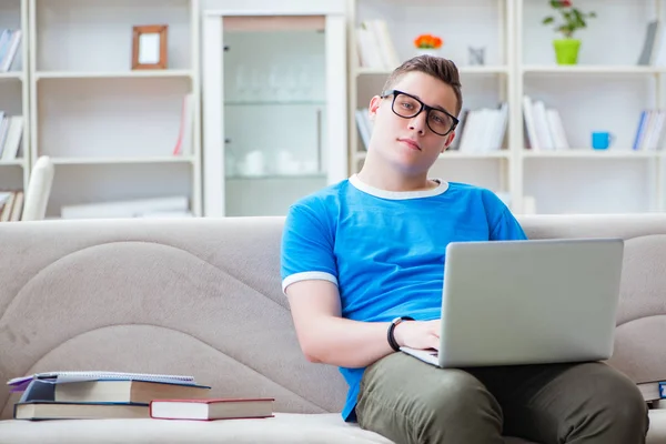 Estudiante joven preparándose para los exámenes que estudian en casa en un sofá — Foto de Stock