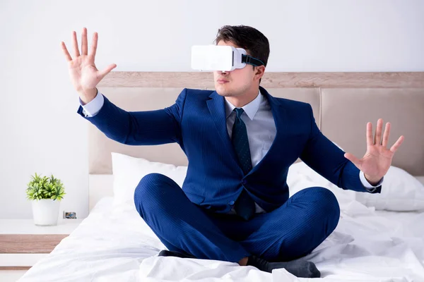 Empresário vestindo um fone de ouvido realidade virtual no quarto — Fotografia de Stock