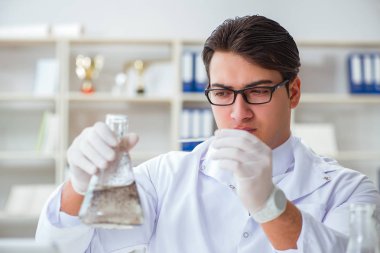 Genç araştırmacı bilim adamı bir su testi kirliliği araştırması yapıyor.