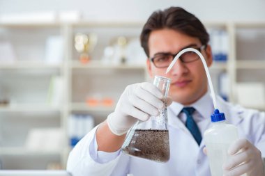 Genç araştırmacı bilim adamı bir su testi kirliliği araştırması yapıyor.