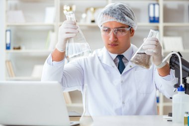 Genç araştırmacı bilim adamı bir su testi kirliliği araştırması yapıyor.