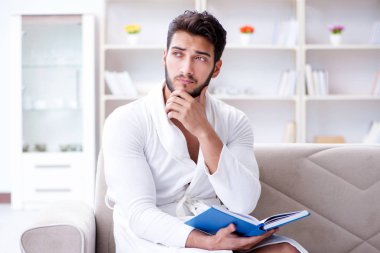 Öğrenci işadamı genç adam bir kitap okuyor.