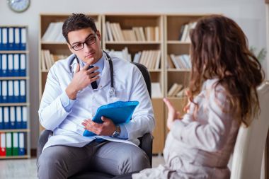 Hamile kadın muayene için doktoru ziyaret ediyor.