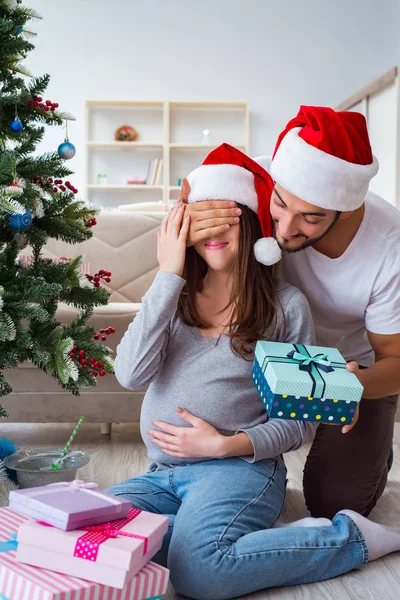 Mladá rodina očekává dítě oslavující Vánoce — Stock fotografie