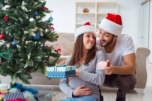 Jeune famille attend bébé célébrant Noël — Photo