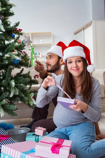 Jeune famille attend bébé célébrant Noël — Photo