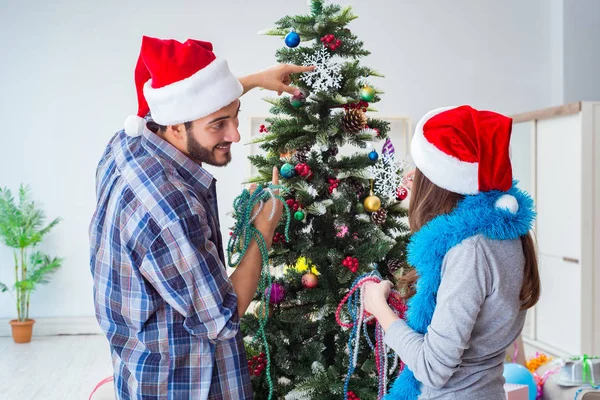 Mladá rodina zdobení vánoční stromeček na šťastné příležitosti — Stock fotografie