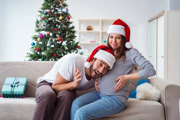 Jeune famille attend bébé célébrant Noël — Photo