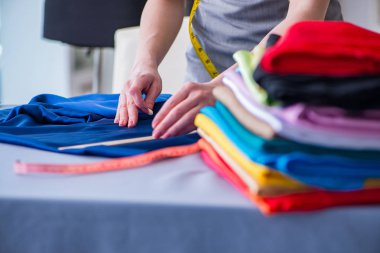 Kadın terzi dikiş dikmek için dikiş dikiyor.