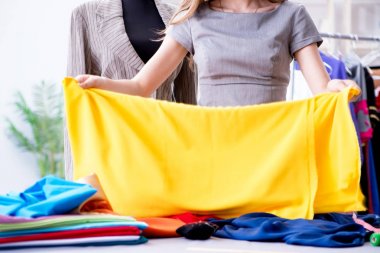 Atölyede çalışan genç bayan terzi yeni elbise üzerinde çalışıyor.