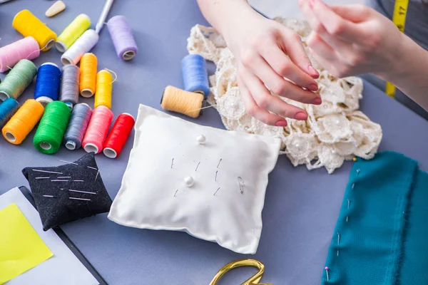 Kadın terzi dikiş dikmek için dikiş dikiyor.