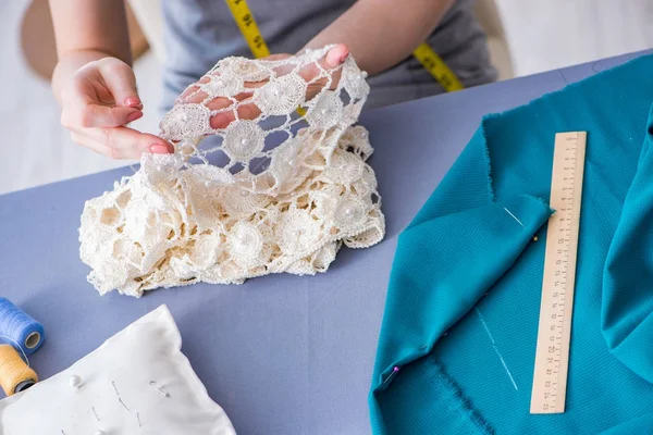 Kadın terzi dikiş dikmek için dikiş dikiyor.