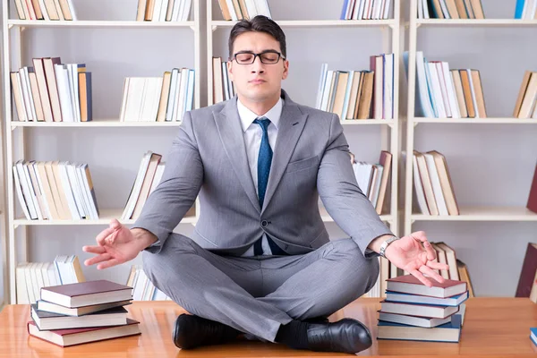 Businessman student in lotus position concentrating  in the libr — Stock Photo, Image