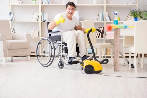 Uomo disabile con aspirapolvere a casa — Foto Stock