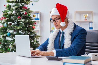İş adamı Noel tatilini ofiste kutluyor.