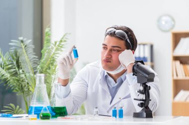 Laboratuvarda virüs aşısı üzerinde çalışan erkek doktor.