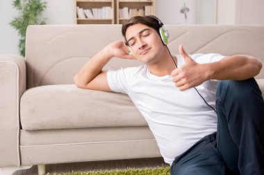 Evde müzik dinleyen bir adam.