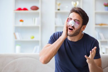 Genç adam estetik cerrahi burnundan sonra evde iyileşiyor.