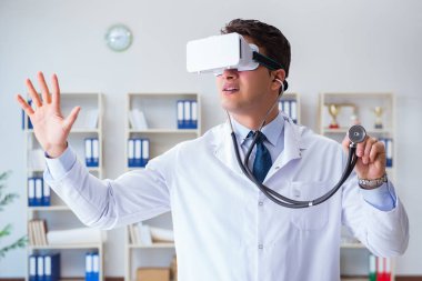Sanal gerçeklik kulaklığı olan genç doktor ofiste çalışıyor.