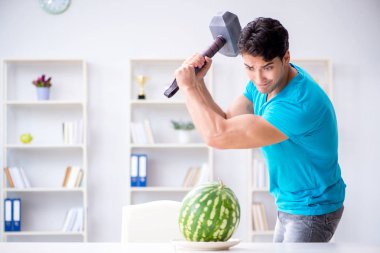 Evde karpuz yiyen bir adam.