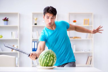 Evde karpuz yiyen bir adam.