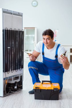 Tamirci müteahhit DIY konseptinde buzdolabını tamir ediyor.