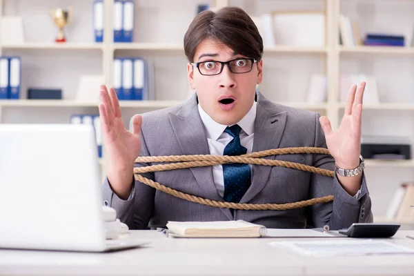 Businessman tied up with rope in office — Stock Photo, Image