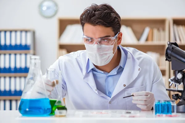 Laboratuvarda virüs aşısı üzerinde çalışan erkek doktor.