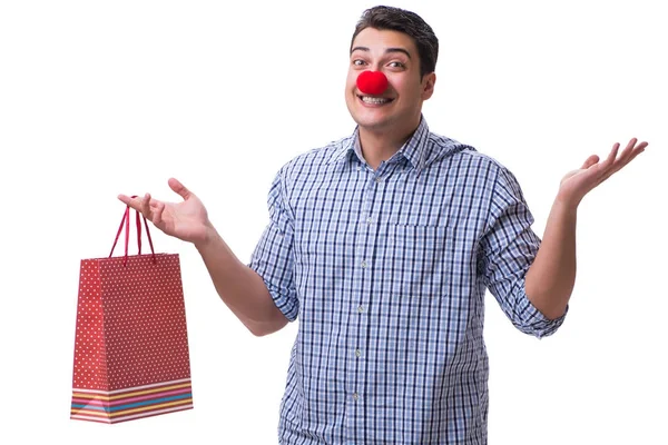 El hombre con una nariz roja divertida sosteniendo un regalo de bolsa de compras es —  Fotos de Stock