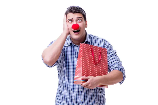 Homem com um nariz vermelho engraçado segurando um presente saco de compras é — Fotografia de Stock