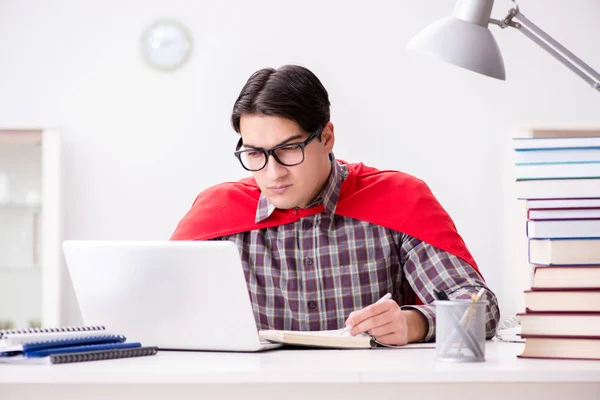 Estudiante súper héroe con una computadora portátil estudiando preparación para los exámenes — Foto de Stock
