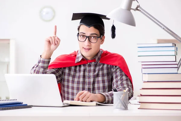 Super hero student wearing a mortarboard studying for exams