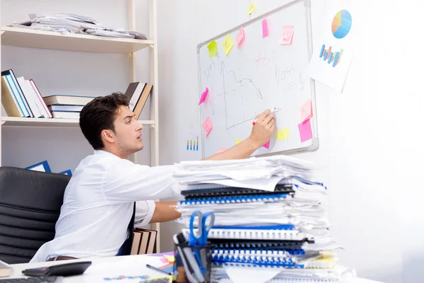 Empresario trabajando en la oficina con montones de libros y papeles — Foto de Stock