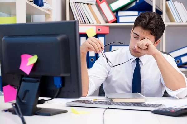 Uomo d'affari che lavora in ufficio con mucchi di libri e carte — Foto Stock